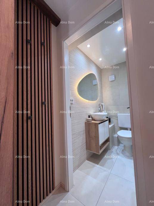 Modernes Gäste-WC mit stilvollem Waschbecken, beleuchtetem Spiegel und Holzakzenten an der Wand.