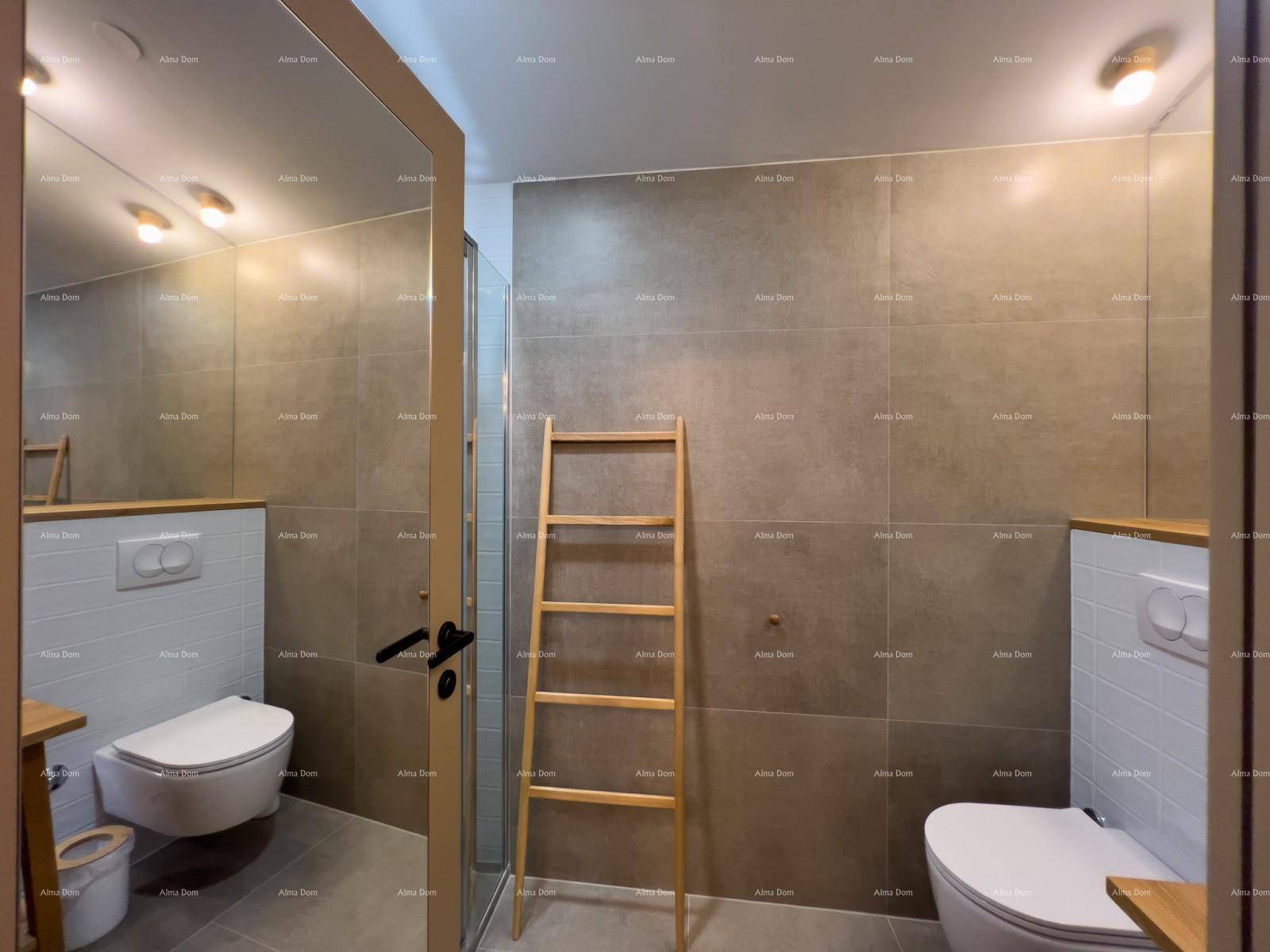 Badezimmer mit zwei Wand-WCs, einem großen Spiegel und modernen grauen sowie weißen Fliesen.