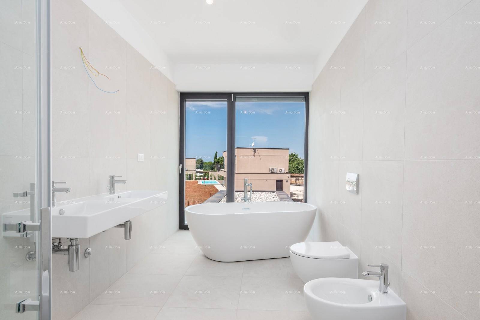 Modernes Badezimmer mit freistehender Badewanne, Doppelwaschbecken und Fenster.