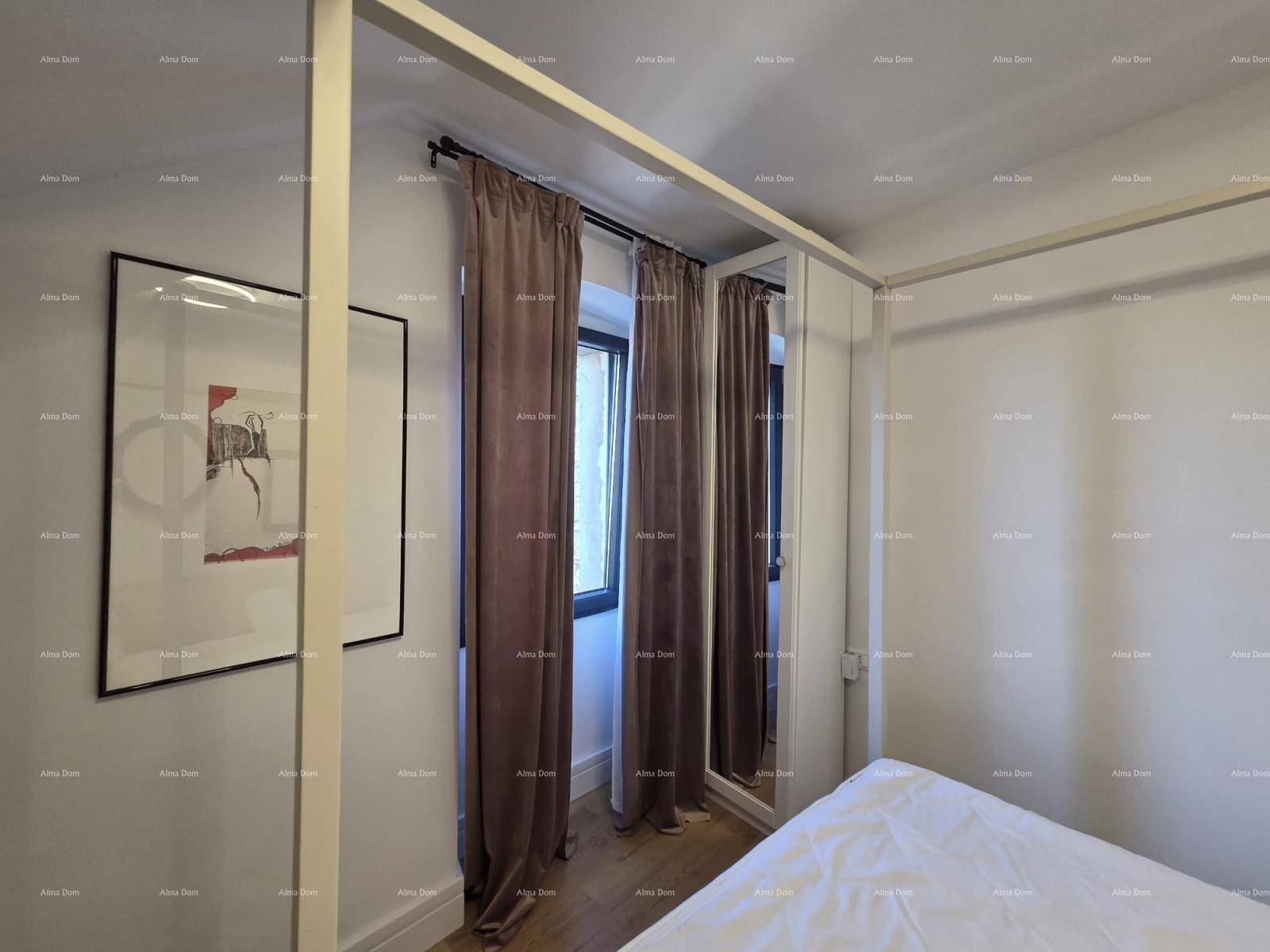 Schlafzimmer mit weißem Himmelbett, dunklen Vorhängen und einem Fenster für natürliches Licht.