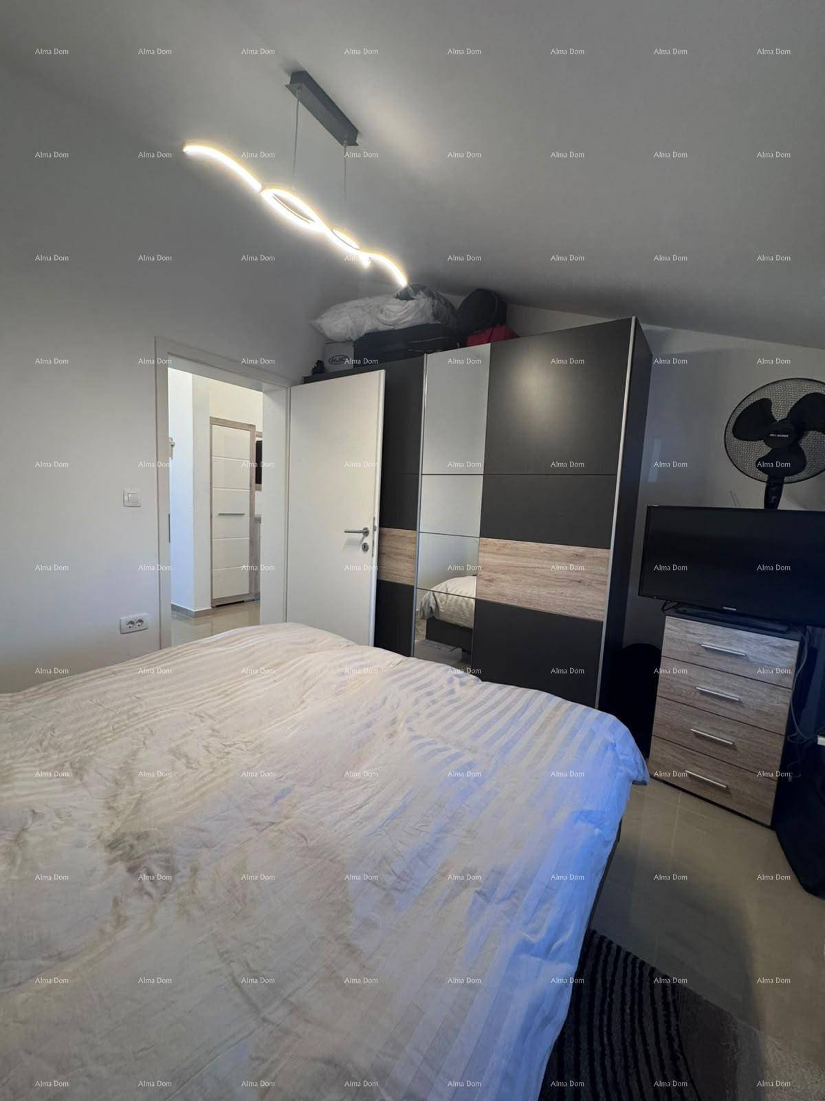 Schlafzimmer mit bequemen Bett und geräumigem Kleiderschrank, unter einer Dachschräge.
