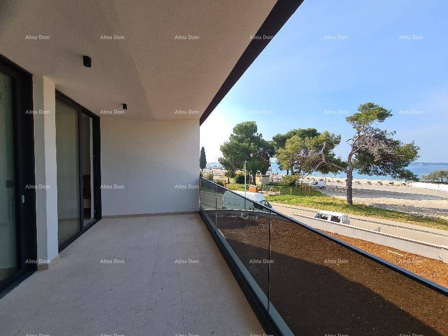 Heller Balkon mit modernem Glasgeländer und Zugang zu den Innenräumen, mit Meerblick.