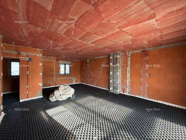 Unfertiger Wohnraum mit Ziegelwänden, Fußbodenheizungsvorbereitung und Fenster für natürliches Licht.