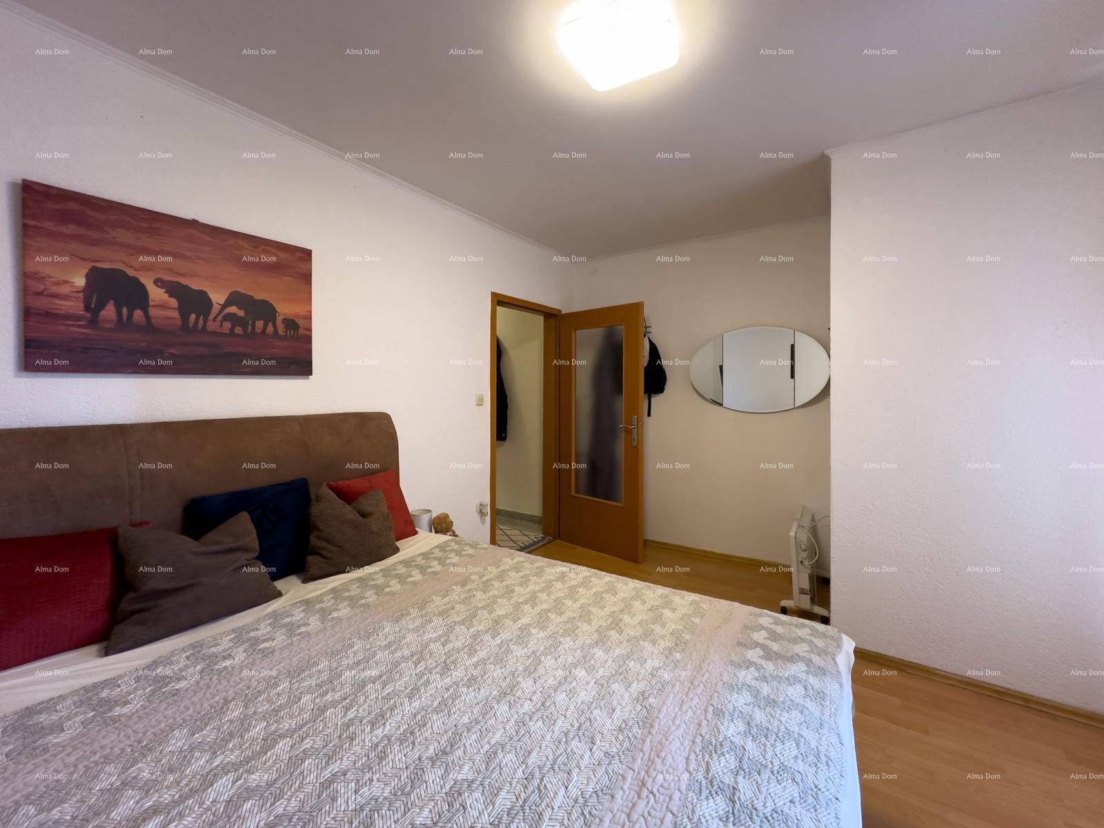 Schlafzimmer mit Doppelbett, Holzboden und einem Spiegel an der Wand.