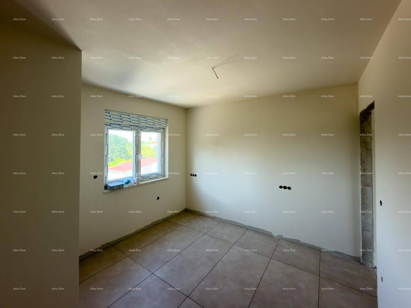 Schlafzimmer im Rohbau mit Fliesenboden und einem Fenster, das einen Blick ins Grüne bietet.