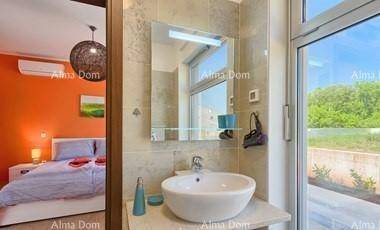 Modernes Badezimmer mit Aufsatzwaschbecken, Spiegel und Blick auf das angrenzende Schlafzimmer.