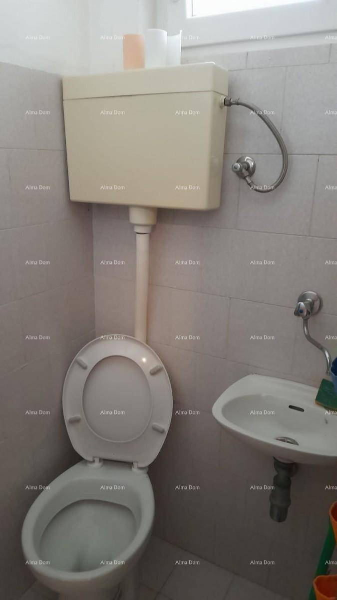 Kleines WC mit Toilette und Waschbecken, ausgestattet mit einfachen Fliesen und einem Fenster.