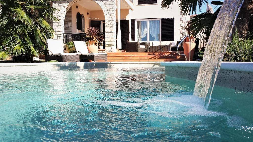Erfrischender Pool mit Wasserspiel und Blick auf die elegante Villa im mediterranen Stil.