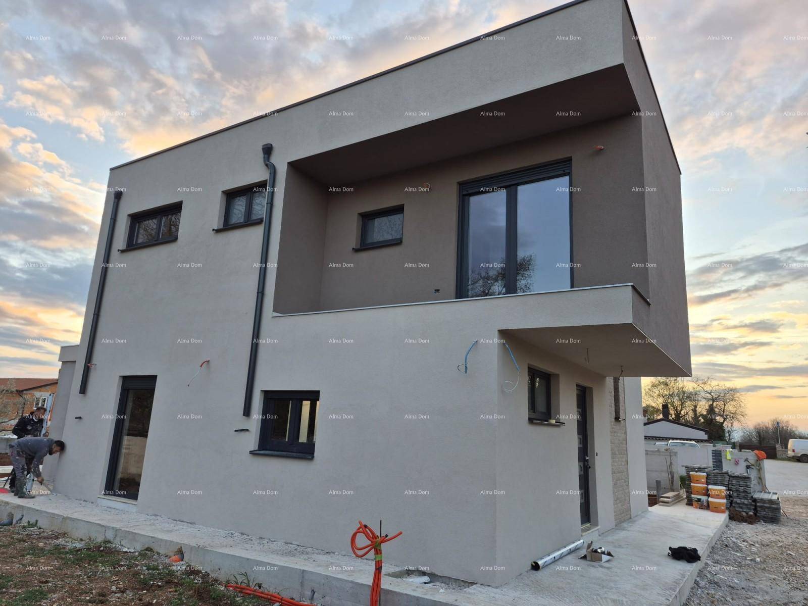 Die Fassade eines modernen Hauses im Bau mit Balkon und Baumaterialien im Vordergrund.