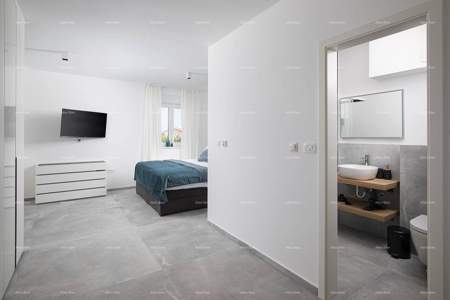 Geräumiges Schlafzimmer mit Doppelbett, Kommode und Zugang zu einem modernen Badezimmer.