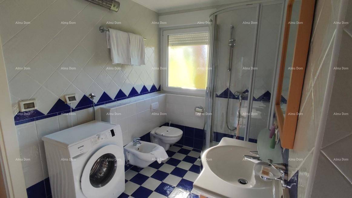 Funktionales Badezimmer mit Duschkabine, Waschmaschine, WC und Bidet, in blau-weißem Design.