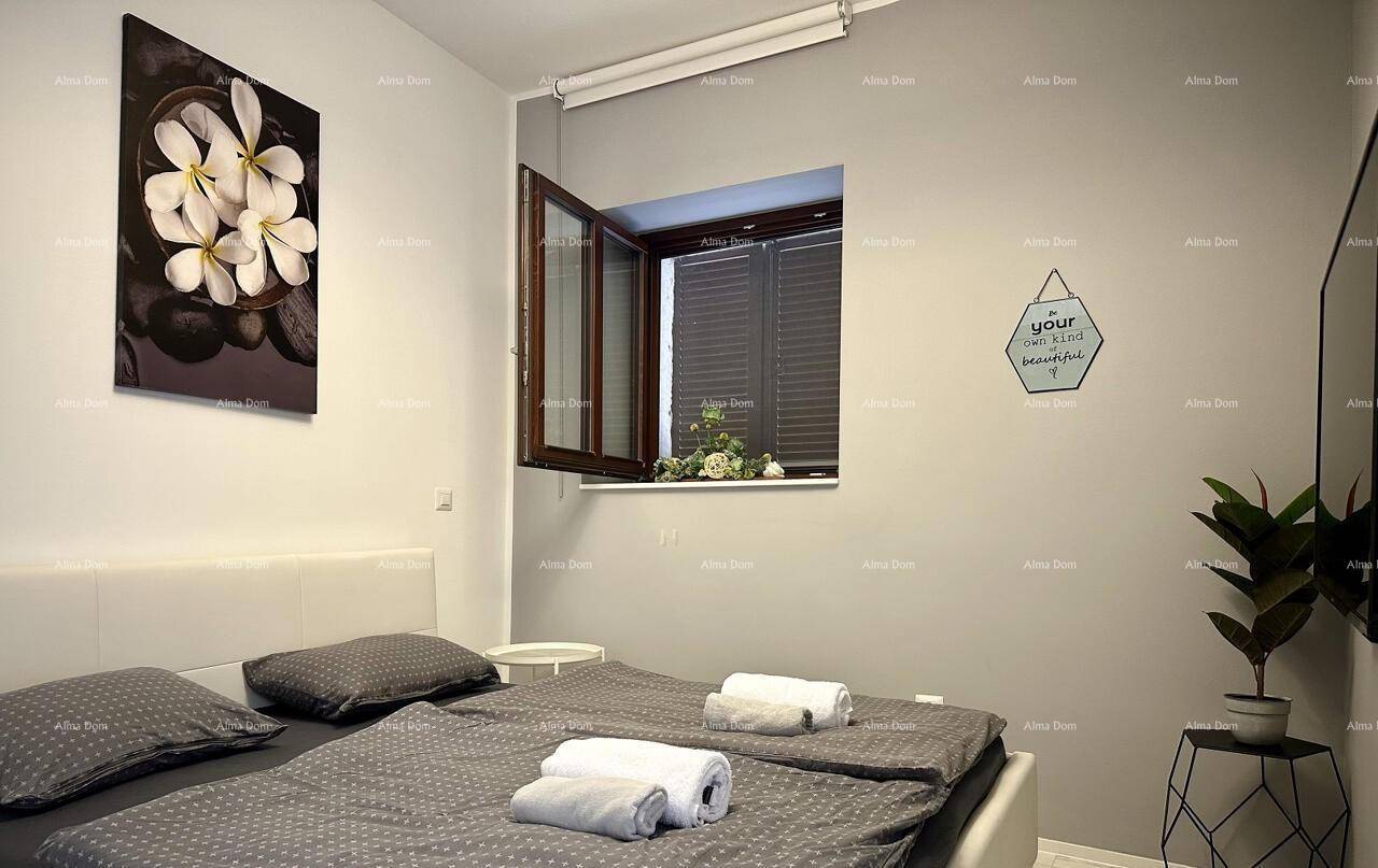 Gemütliches Schlafzimmer mit Doppelbett, grauer Bettwäsche und einem Fenster.