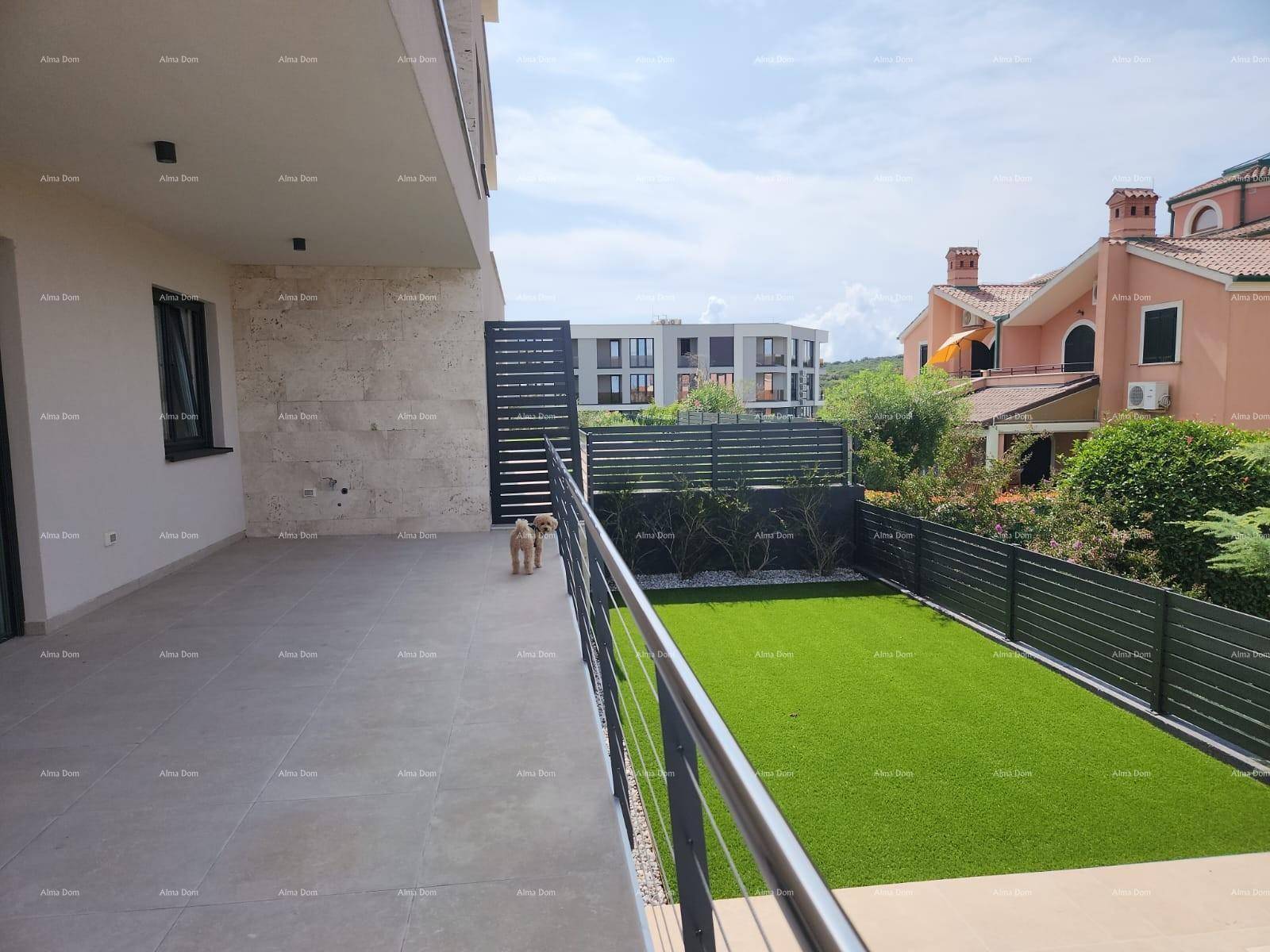 Weitläufige Terrasse mit Kunstrasenfläche, modernem Zaun und Blick auf die umliegenden Häuser.