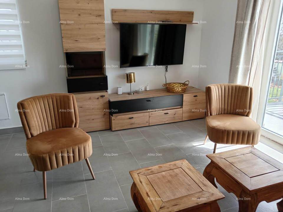 Detailansicht des Wohnzimmers mit modernem TV-Möbel, zwei Sesseln und Holztischen.