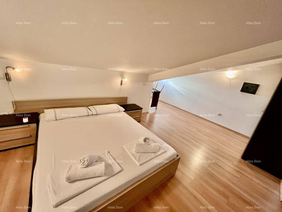 Gemütliches Schlafzimmer im Dachgeschoss mit Doppelbett und Holzboden unter einer Dachschräge.