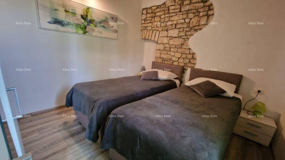 Schlafzimmer mit zwei Einzelbetten, Nachttisch und einer charmanten Steinwand, die rustikalen Flair bietet.