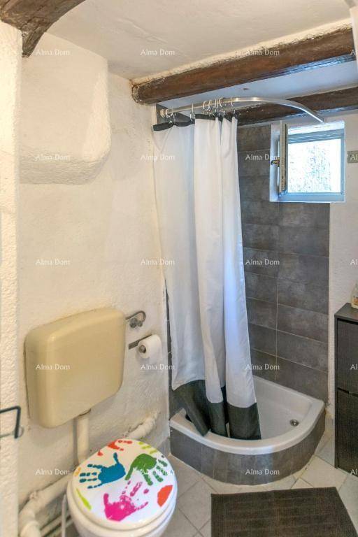 Kleines Badezimmer mit Dusche, Toilette und Fliesen an der Wand.
