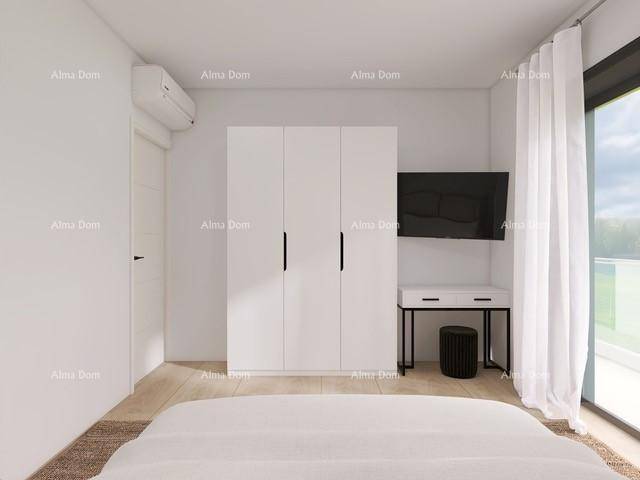 Helles Schlafzimmer mit weißem Kleiderschrank, Fernseher und großem Fenster.