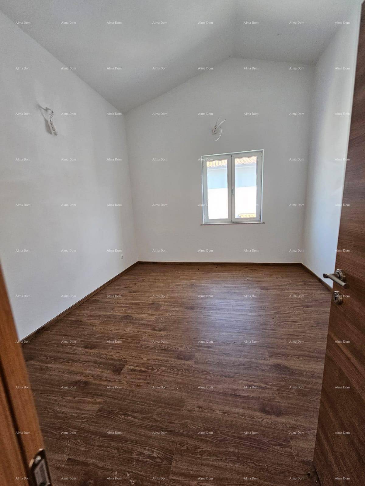 Leeres Schlafzimmer mit Laminatboden, weißen Wänden und einem Fenster.