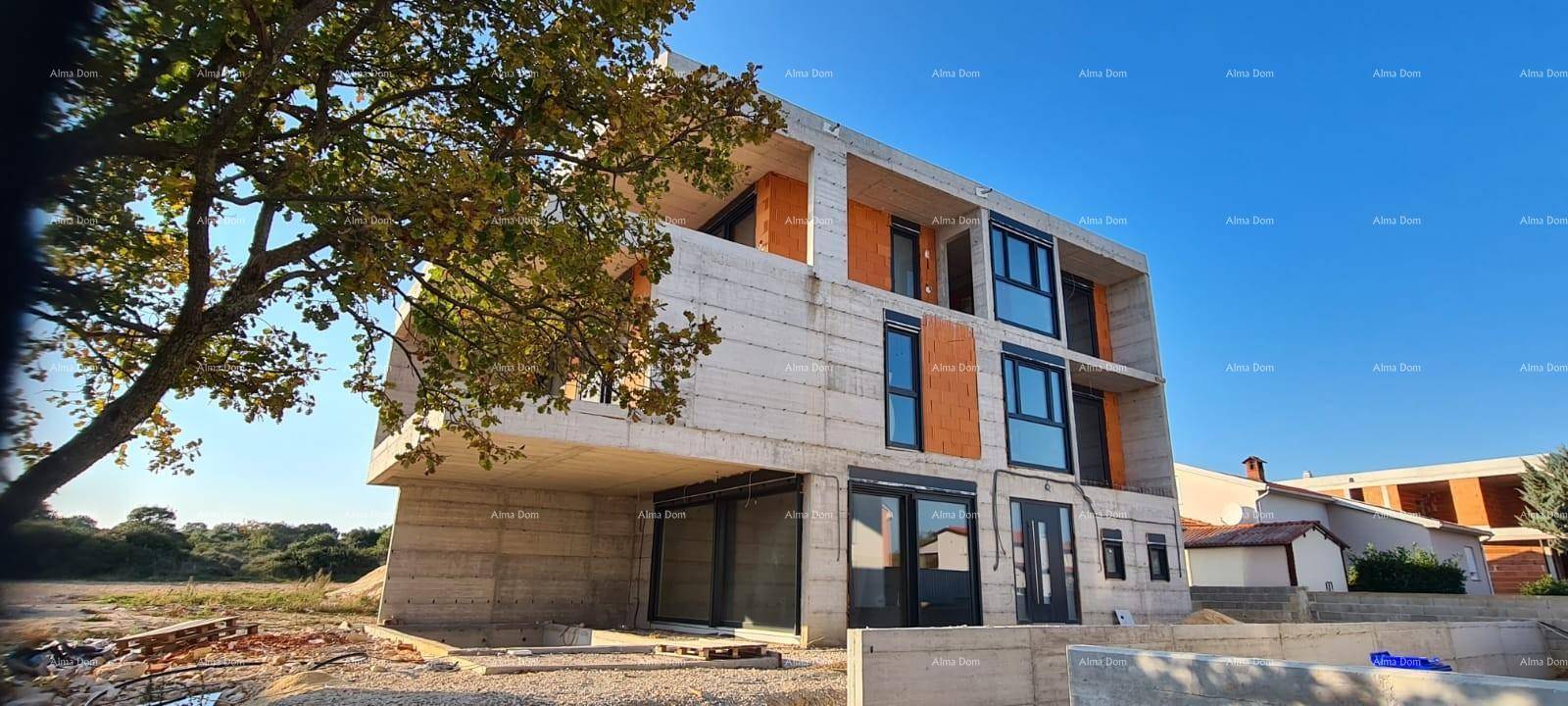 Neubau in Betonbauweise mit großen Fensteröffnungen und sichtbaren Balkonen im Bauzustand.