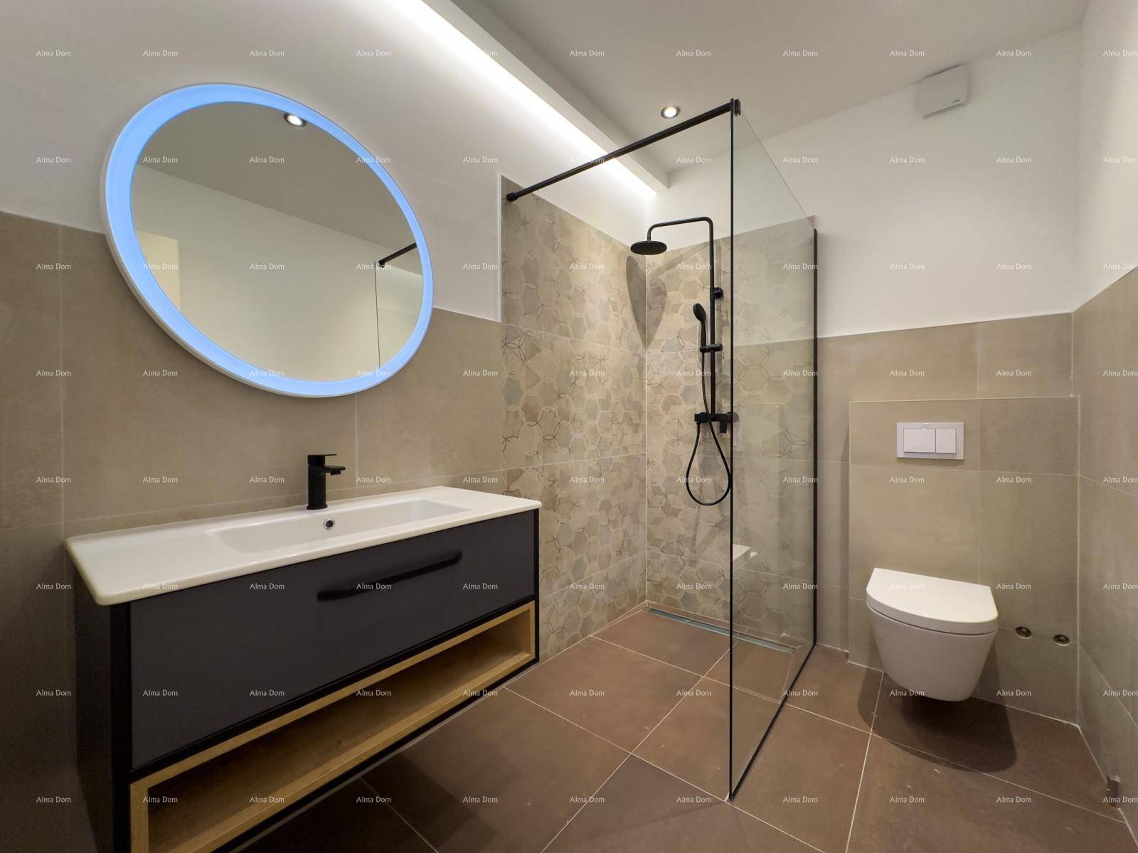Modernes Badezimmer mit beleuchtetem Spiegel, Waschtisch, begehbarer Dusche und Wand-WC.