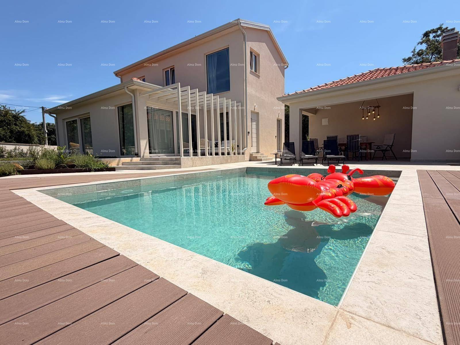 Außenansicht der Villa mit großem Pool und Holzterrasse an einem sonnigen Tag.