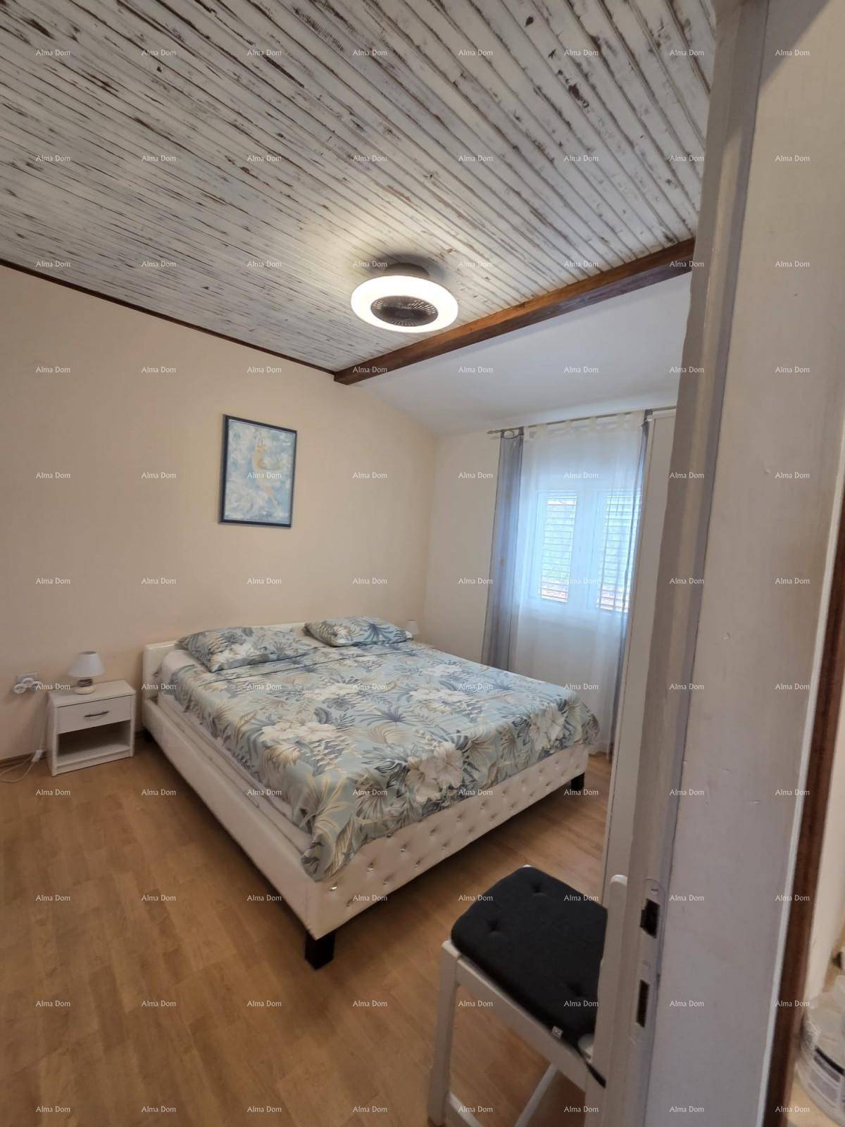 Gemütliches Schlafzimmer mit Doppelbett, Holzbalkendecke und hellem Laminatboden.