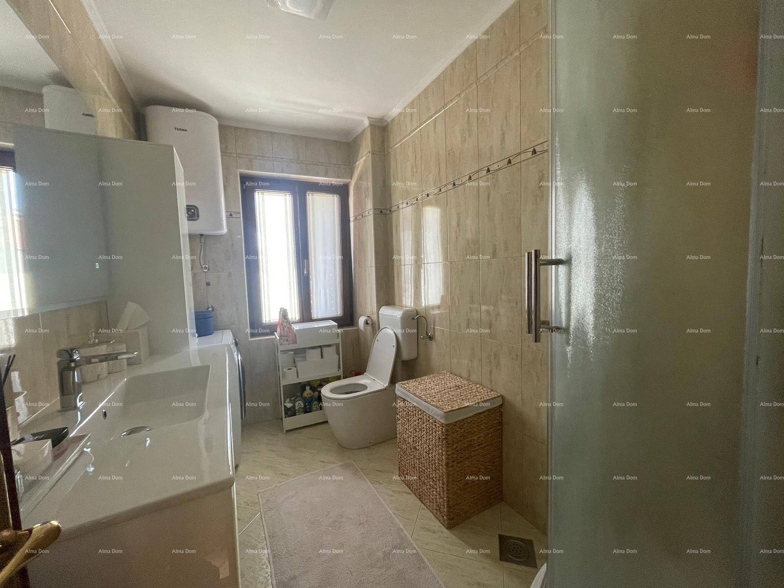 Badezimmer mit Duschkabine, Waschbecken, Toilette und Fenster für Tageslicht.