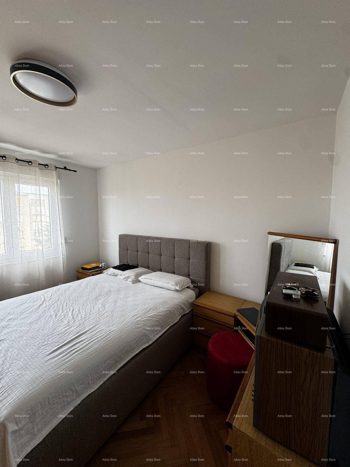 Helles Schlafzimmer mit Doppelbett, Nachttischen und einem modernen Deckenlicht.