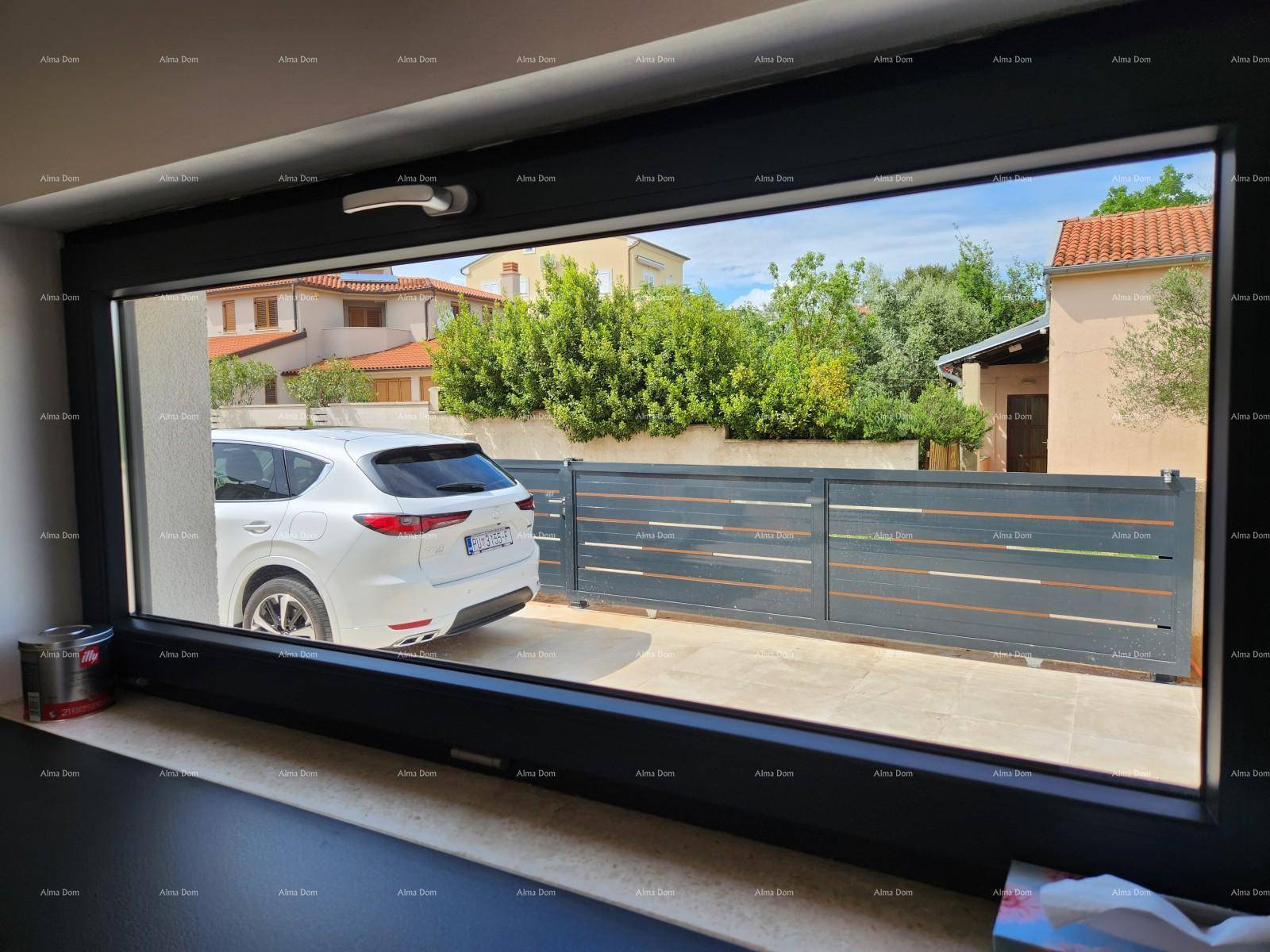 Blick aus dem Küchenfenster auf die Einfahrt mit einem Auto und die umliegende Nachbarschaft.