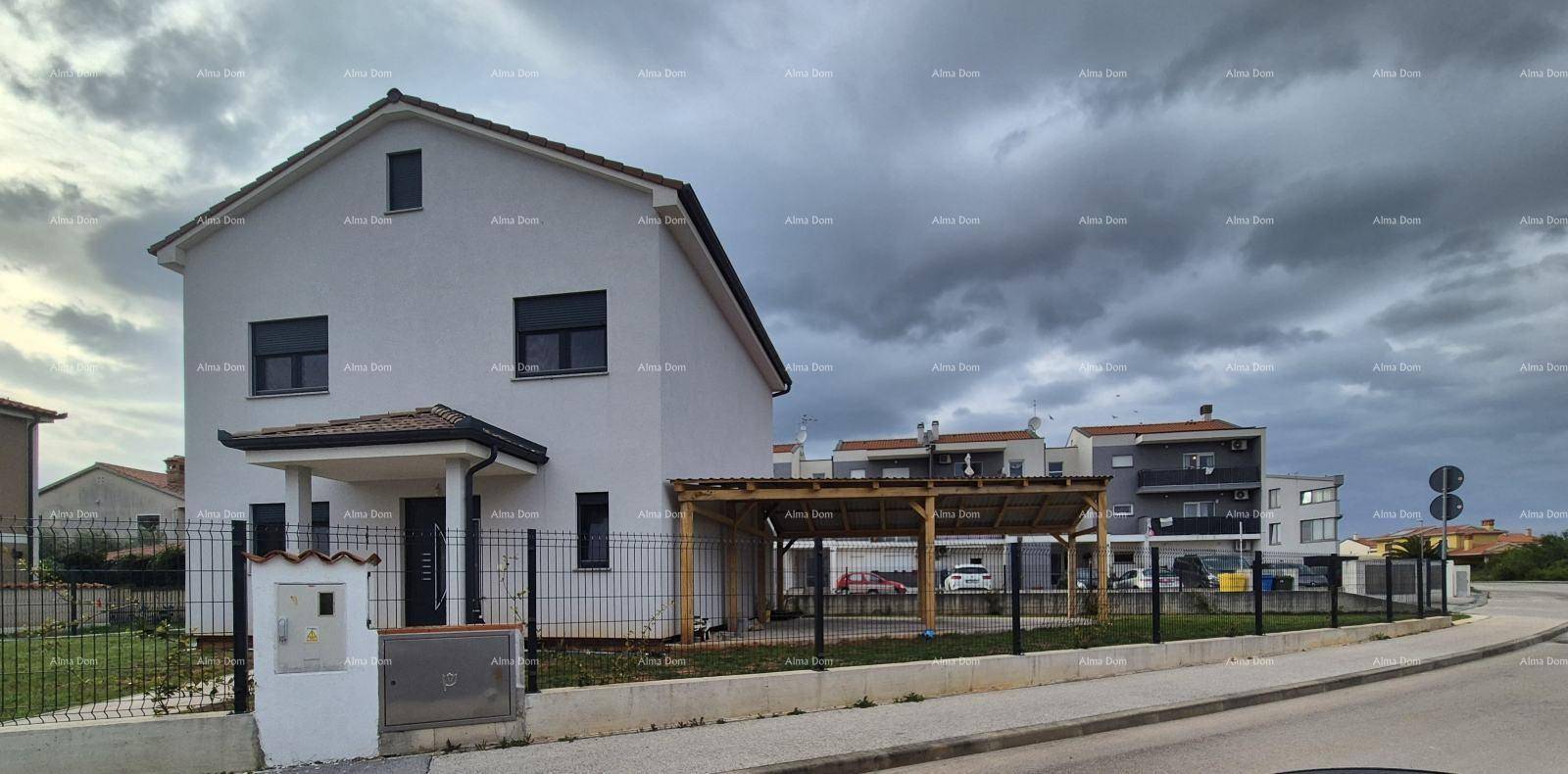 Ansicht des modernen Wohnhauses von der Seite mit Carport und bewölktem Himmel.