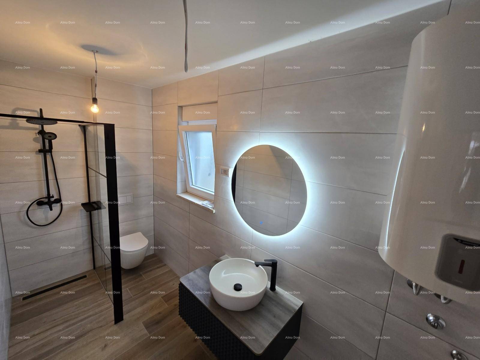 Modernes Badezimmer mit begehbarer Dusche, beleuchtetem Spiegel und stilvollen Fliesen.