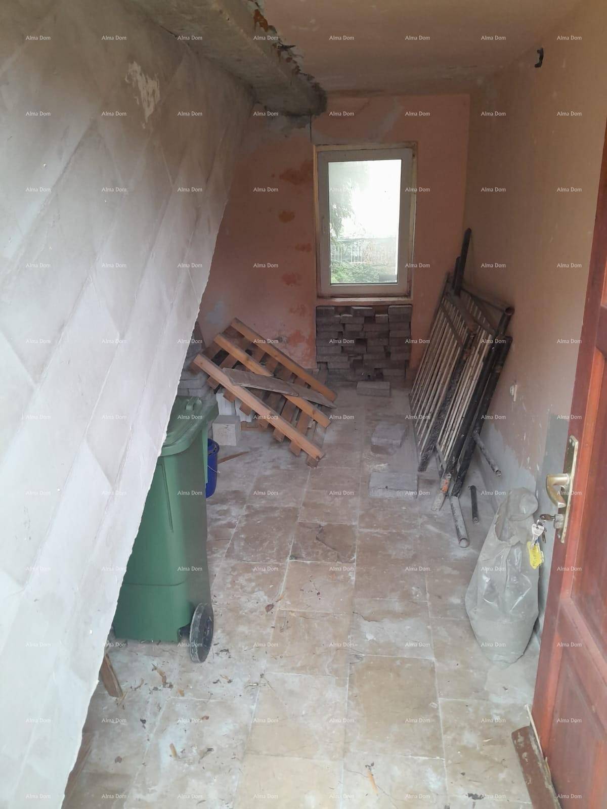 Unfertiger Dachbodenraum mit Fenster, unverputzten Wänden und gelagerten Baumaterialien.