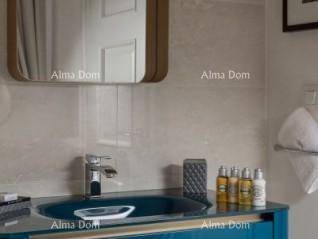 Modernes Badezimmer mit einem stilvollen blauen Waschbecken und einem eleganten Wandspiegel.