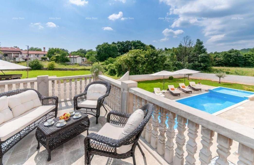 Möblierte Terrasse mit Rattanmöbeln, Balustrade und weitem Blick über den Poolbereich und die Landschaft.