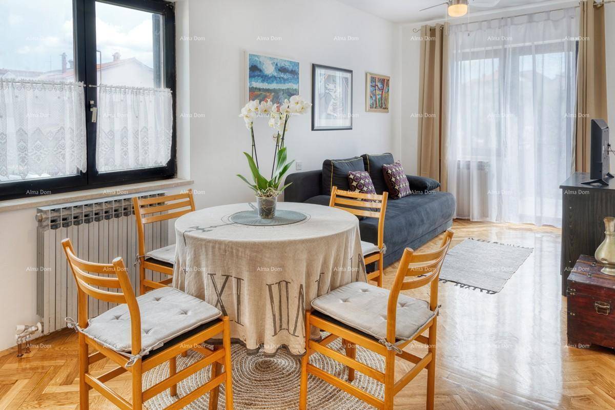 Gemütlicher Wohn- und Essbereich mit Holztisch, Sofa und großen Fenstern.
