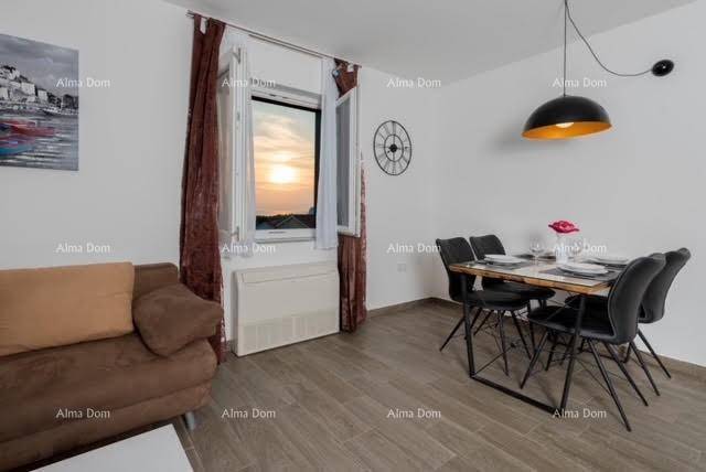 Wohn-Essbereich mit Esstisch und Sofa, beleuchtet durch das Fenster mit Blick auf den Sonnenuntergang.
