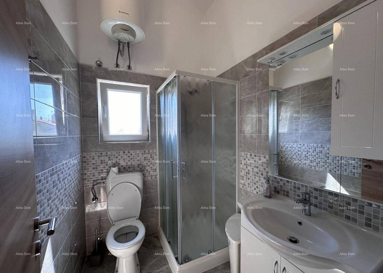 Funktionales Badezimmer mit Waschbecken, Toilette und Duschkabine, hell gefliest.