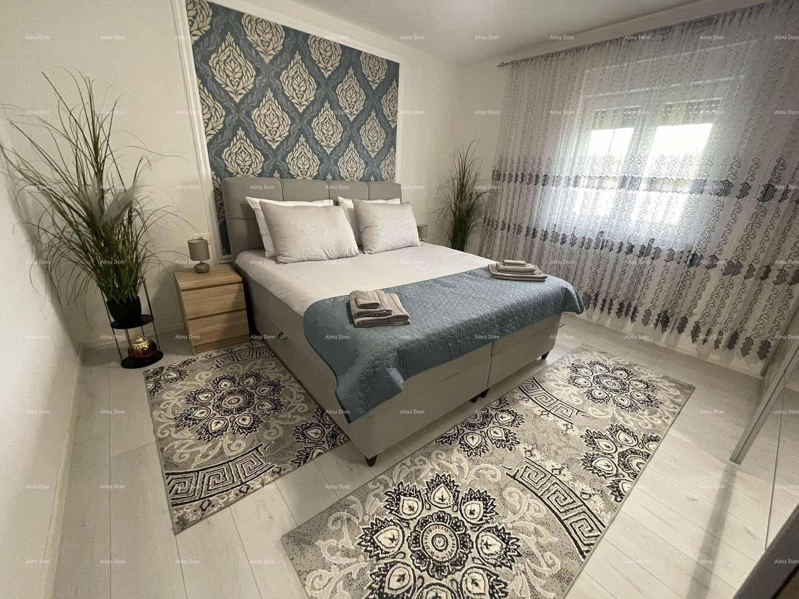 Stilvolles Schlafzimmer mit Doppelbett, dekorativer Tapete, hellem Laminatboden und großen Fenstern.