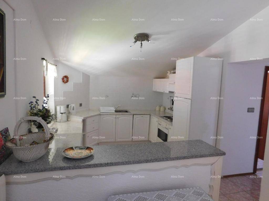 Dachgeschossküche mit weißen Schränken, Granitarbeitsplatte und schrägen Decken.