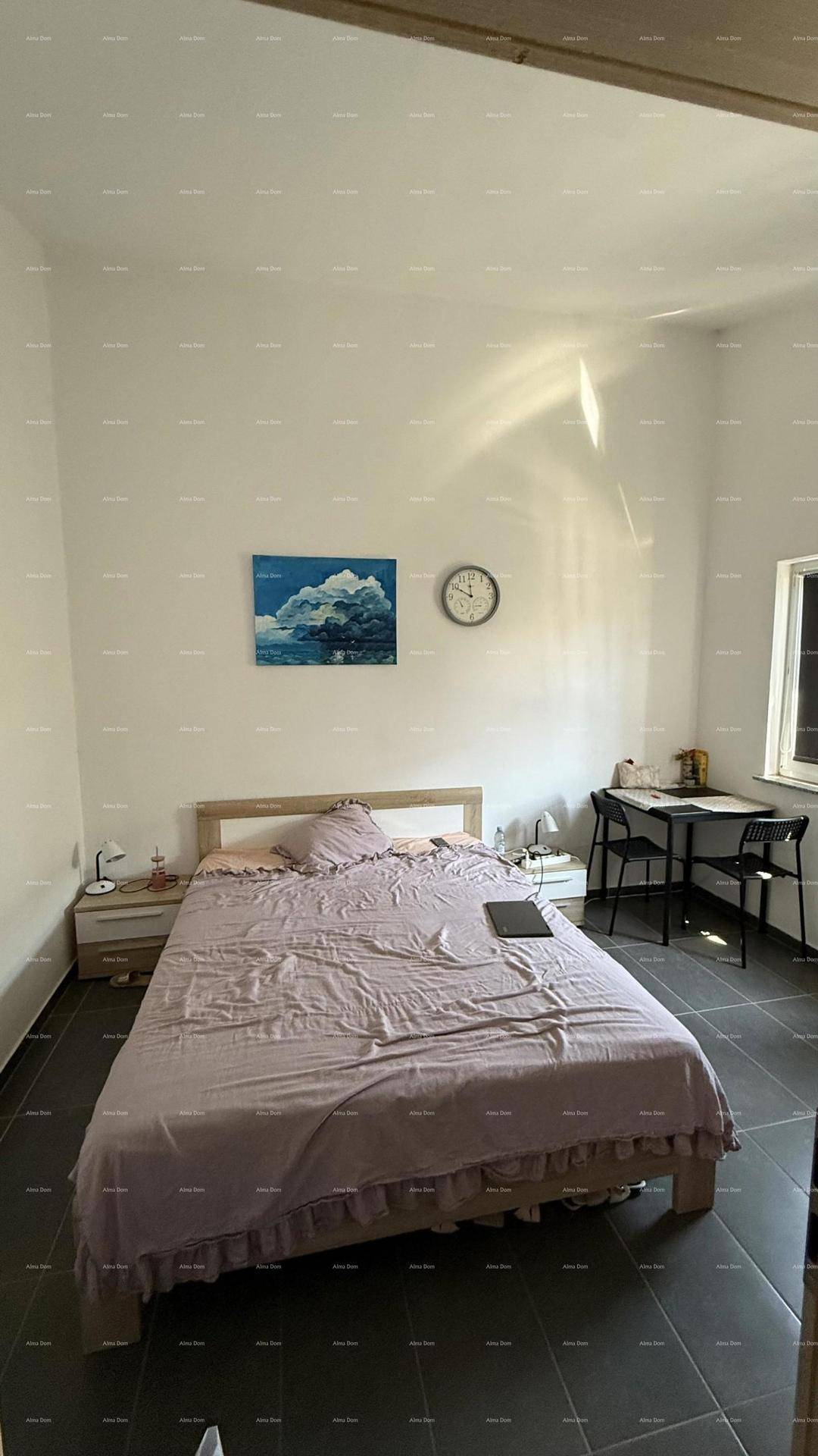 Helles Schlafzimmer mit Doppelbett, Nachttischen und einem kleinen Tisch mit Stühlen am Fenster.