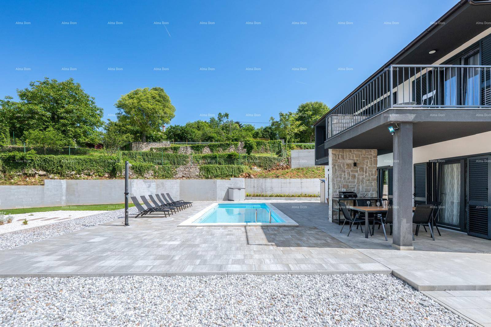 Weitläufiger Außenbereich mit Pool, Kiesgarten und moderner Architektur des Hauses.