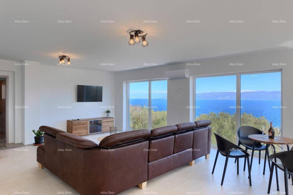 Geräumiges Wohnzimmer mit bequemer Couch, Fernseher und weitem Meerblick.