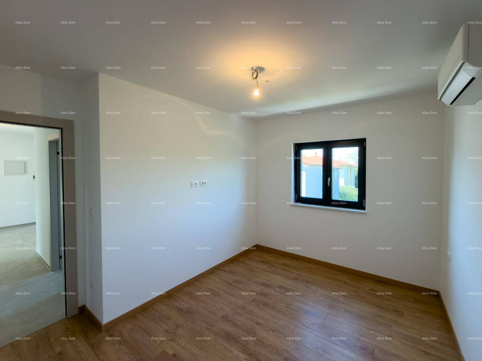 Schlafzimmer mit Holzfußboden, Klimaanlage und weiß gestrichenen Wänden.