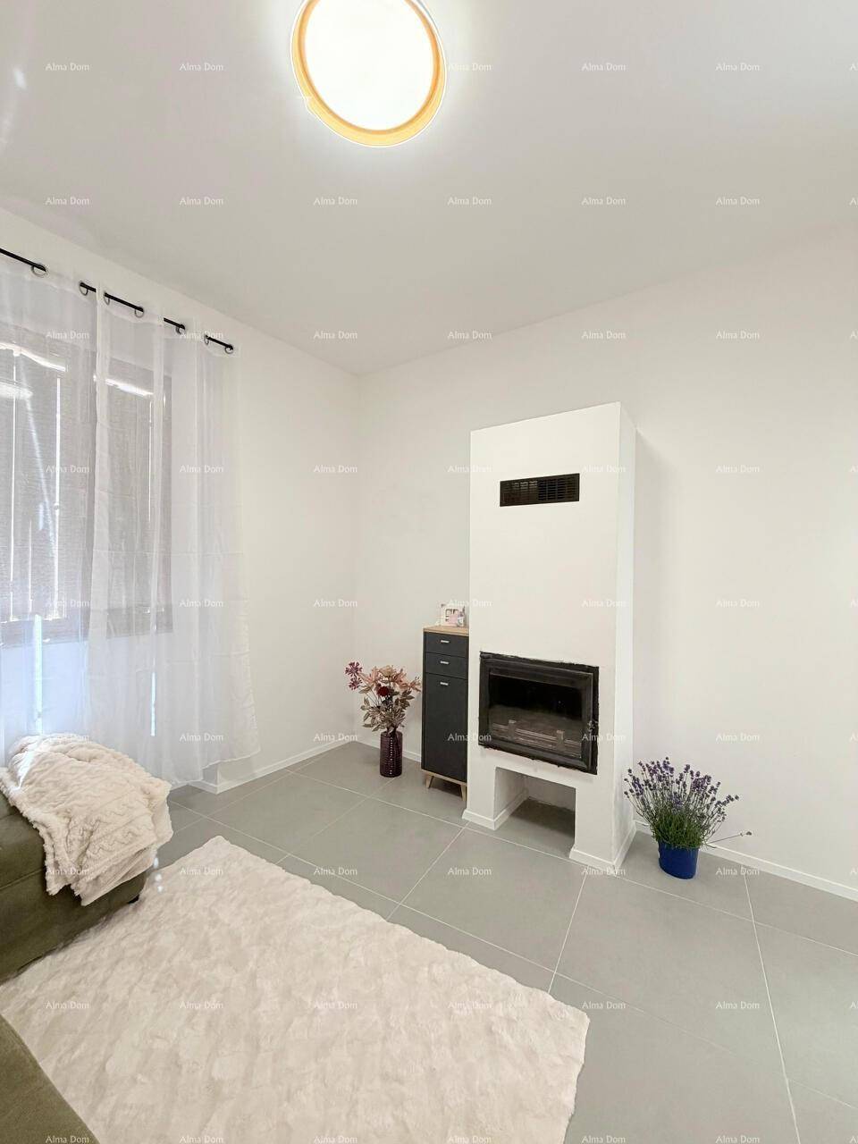 Gemütliches Wohnzimmer mit modernem Kamin, hellem Fliesenboden und viel Tageslicht.
