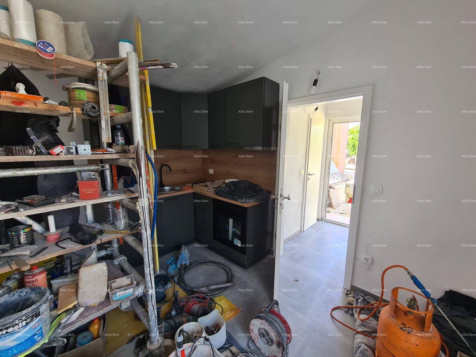 Raum im Bau mit einer kleinen Küchenzeile, umgeben von Werkzeugen und Baumaterialien.