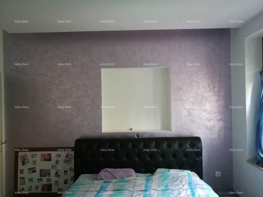 Schlafzimmer mit gepolstertem Bettkopfteil und einer dekorativen Nische in der Wand.
