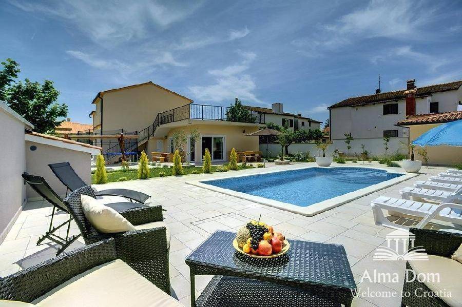 Große Sonnenterrasse mit Pool, Liegestühlen und gemütlicher Lounge-Ecke für Entspannung.