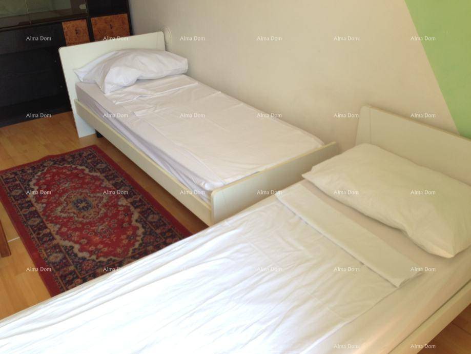 Schlafzimmer mit zwei Einzelbetten und einem Teppich auf dem Holzboden.