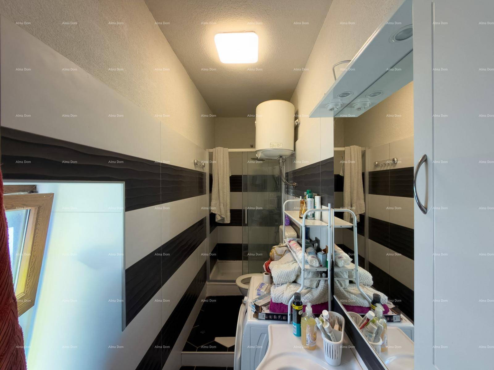 Modernes Badezimmer mit schwarz-weißen Fliesen, Dusche und Waschbecken.